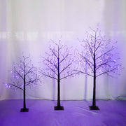 Halloween ghost trees with lights illuminated by purple lights, creating an eerie decorative effect for spooky season.